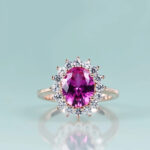 Princess Diana inspired pink sapphire ring with a radiant center stone surrounded by a halo of diamonds